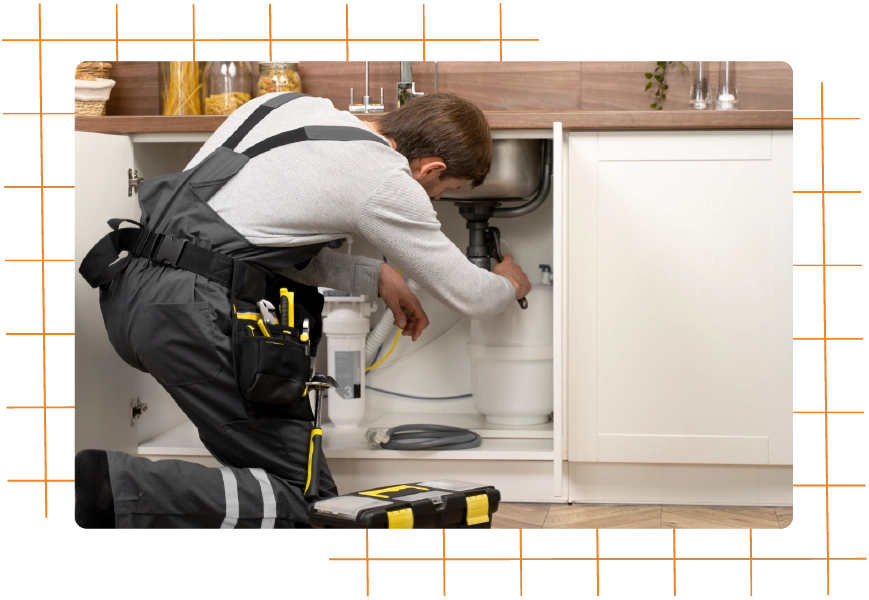 Plumber fixing pipes under kitchen sink for residential service